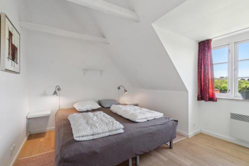a bedroom with a bed with two pillows on it at Holiday Apartment For 4 With Shared Pool in Åkirkeby