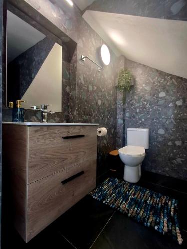 a bathroom with a toilet and a sink and a mirror at infinity sky stay in episkopi-heraklion