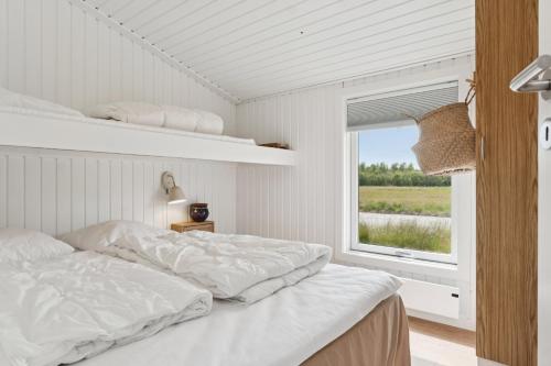 a white bedroom with a bed and a window at Scenic Holiday Home In Bratten in Jerup