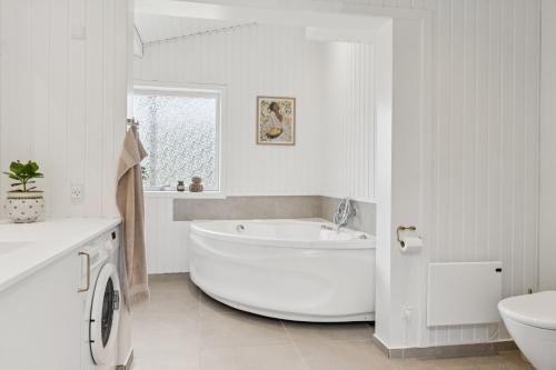 a white bathroom with a large tub and a sink at Scenic Holiday Home In Bratten in Jerup