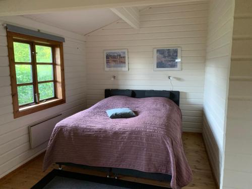 a bedroom with a bed with a purple blanket at Experience The Forest And Sea in Ålsgårde