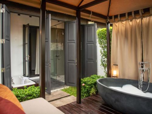 a bathroom with a bath tub and two sinks at Sofitel Luang Prabang in Luang Prabang