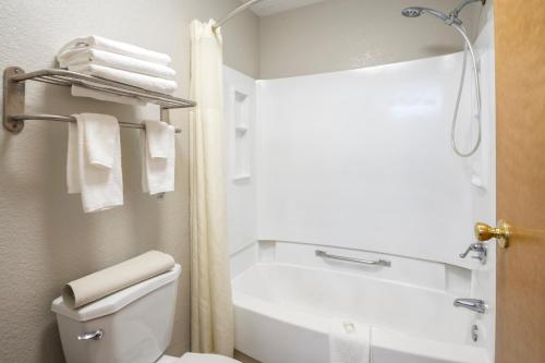 a bathroom with a tub and a toilet and towels at Quality Suites Hickory South in Hickory