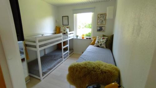 a small room with a bunk bed and a couch at Cozy Summerhouse With Spectacular Views in Ølsted