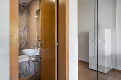 a bathroom with a sink and a glass door at Coreto Bento Freitas in Vila do Conde
