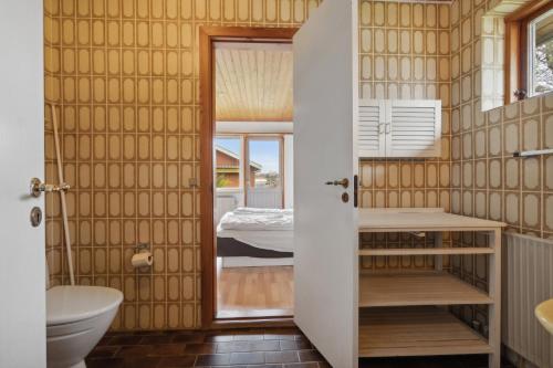 a bathroom with a toilet and a sink and a bed at Cozy Holiday Home In Thisted in Thisted