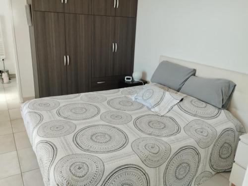 a bedroom with a large bed with a brown cabinet at Mèze joli T2 proche du centre et de la plage in Mèze