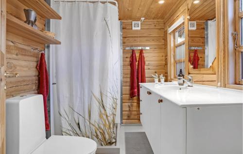 a bathroom with a white sink and a toilet at Cozy Log Cabin With A Panoramic View in Glesborg