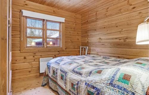 a bedroom with a bed in a log cabin at Cozy Log Cabin With A Panoramic View in Glesborg
