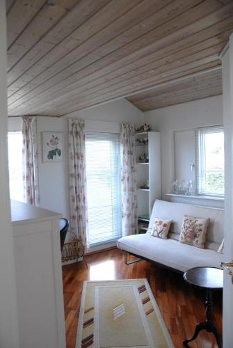 a living room with a couch and two windows at Outstanding Close To Nice Beachh in Karrebæksminde
