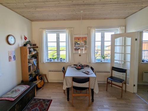 a dining room with a table and chairs and windows at Lovely 2-Story Cabin By The Sea On Bornholm in Svaneke