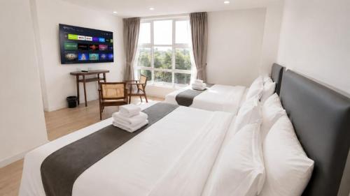 a bedroom with a large bed with white pillows at Lawson Inn in Sibu