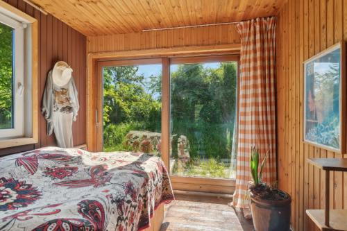 a bedroom with a bed and a large window at Romantic Retreat Close To The Beach in Fårevejle