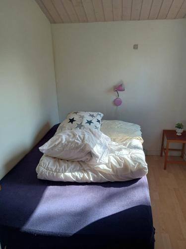 a bed with white sheets and pillows in a room at Charming Summer House In An Idyllic Area in Gylling
