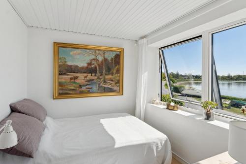 a white bedroom with a bed and a window at Lovely Beach House With Panoramic View in Martofte