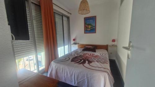 a bedroom with a bed and a large window at Grand T3 face au port avec sa terrasse , parking privatif in Saint-Cyprien-Plage