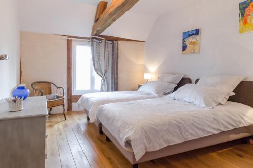 a bedroom with two beds and a window at Le clos des berdins in Saint-Jean-de-Bonneval