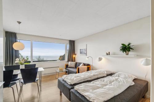 a bedroom with a bed and a table and chairs at Lovely Holiday Apartment Consumption Included in Allinge