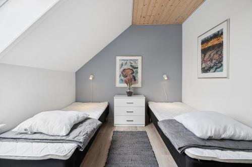 two beds in a room with white walls at Holiday Apartment With Pool On Bornholm in Gudhjem