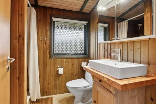 a bathroom with a white sink and a toilet at Cozy Summer House In Trend in Løgstør