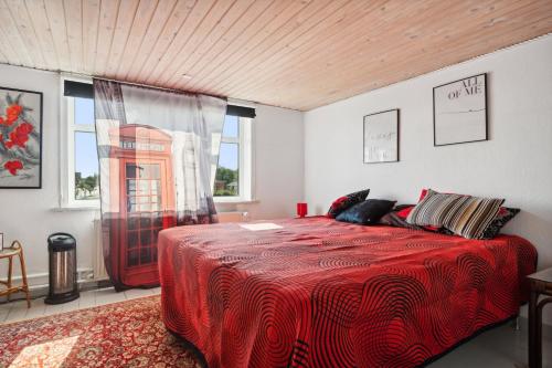 a bedroom with a red bed and a phone booth at Summer House In Thyholm in Thyholm