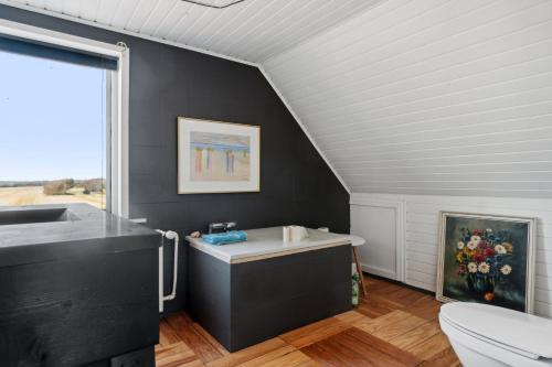 a black bathroom with a sink and a toilet at Summer House In Thyholm in Thyholm
