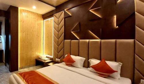 a bedroom with a large bed with orange pillows at Hotel The Novelty in Kānpur