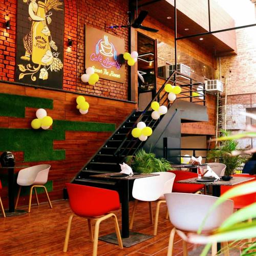 a restaurant with red and white chairs and a table at Hotel The Novelty in Kānpur