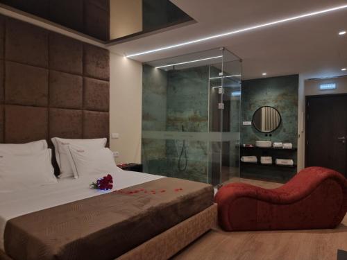 a bedroom with a bed and a glass shower at Motel Unique Private Suites in Leça da Palmeira