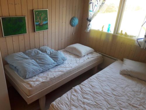 a bedroom with two beds in a room with a window at Holiday Home Near Hvalpsund in Farsø