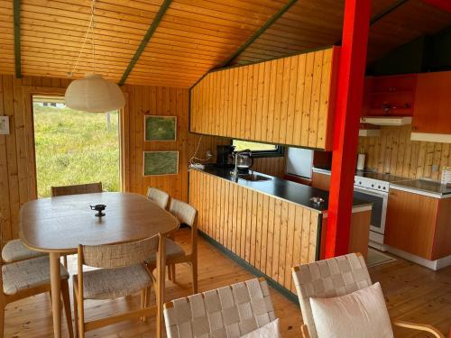 a kitchen and dining room with a table and chairs at 70S Charm Just 300 M From The Beach in Blokhus
