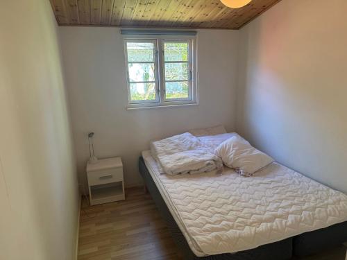 a small bedroom with a bed and a window at Holiday Home Near Nordstrand Nykøbing Sj in Nykøbing Sjælland