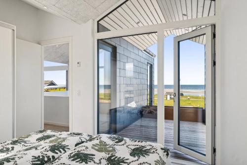a bedroom with a bed and a view of the ocean at Seaside Cottage With A Stunning View in Allingåbro