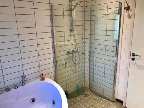 a bathroom with a bath tub and a shower at Fantastic House With A Beautiful View in Ebeltoft