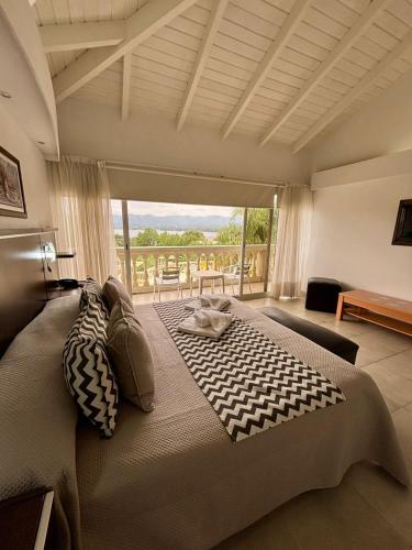 a bedroom with a large bed with a view at Villa La Font Apart Hotel & Spa in Villa Carlos Paz