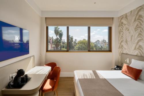 a room with two beds and a desk and a window at Hotel Ybarra Sevilla in Seville