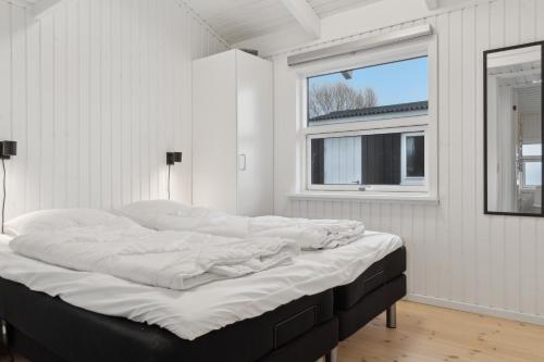 a large bed in a room with a window at Cozy Holiday Home On Orø in Orø