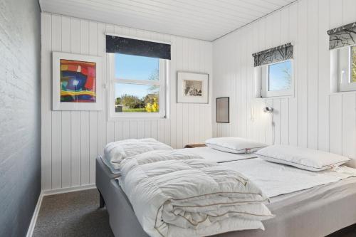 a white bedroom with two beds and two windows at Super Nice Holiday Home With Whirlpool in Højslev
