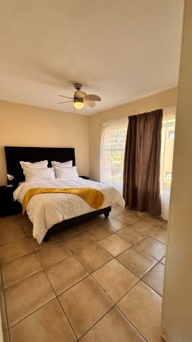 a bedroom with a bed and a ceiling fan at Success Guesthouse in Nelspruit