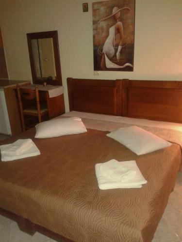 a bedroom with a bed with two towels on it at Guesthouse Adonis in Kato Loutraki