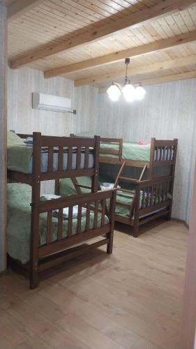 two wooden bunk beds in a room with a ceiling at Rati's Oda in Aspindza