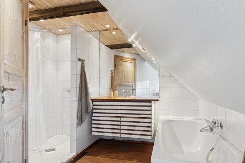 a bathroom with a bath tub and a sink at Idyllic Half-Timbered House For 10 Guests in Kettinge