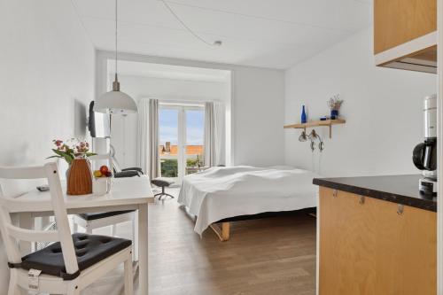 a white room with a bed and a table at Pension Koch Apartment 6 in Gudhjem