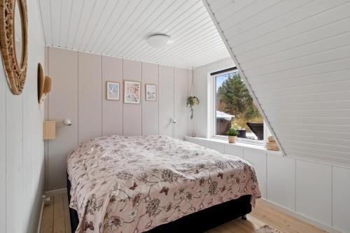 a bedroom with a bed and a window at Holiday Home With Spa Sauna And Hot Tub in Farsø
