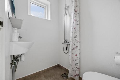 a white bathroom with a toilet and a sink at Holiday Home With Spa Sauna And Hot Tub in Farsø