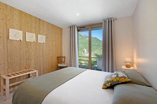 a bedroom with a bed and a large window at Maison "Casabert" in Saint-Martin-de-la-Porte