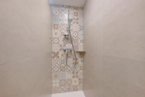 a shower in a bathroom with a tile wall at Maison "Casabert" in Saint-Martin-de-la-Porte