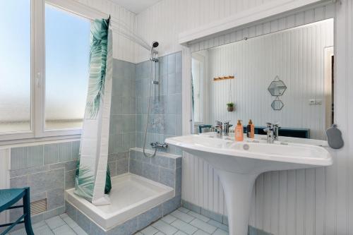a white bathroom with a sink and a shower at Vacances chez Lulu in Batz-sur-Mer