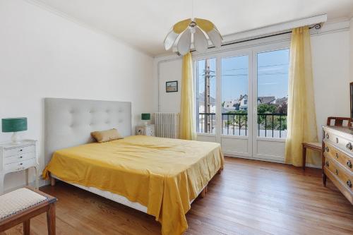 a bedroom with a bed and a large window at Vacances chez Lulu in Batz-sur-Mer