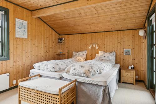 two beds in a room with wooden walls at Summerhouse In Peaceful Surroundings in Pandrup